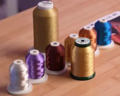 Metallic embroidery thread in different colors displayed on spools Metallic embroidery thread in different colors displayed on spools