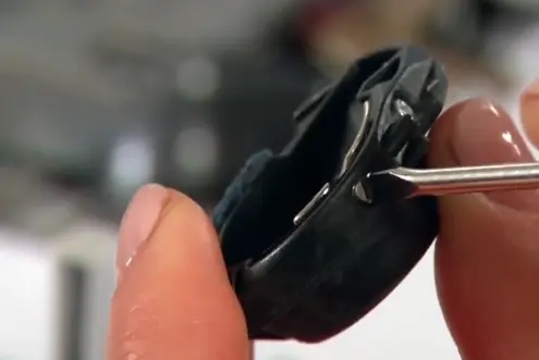 Close-up of bobbin case adjustment in embroidery machine showing the correct setup to prevent thread tangles and bird nesting.